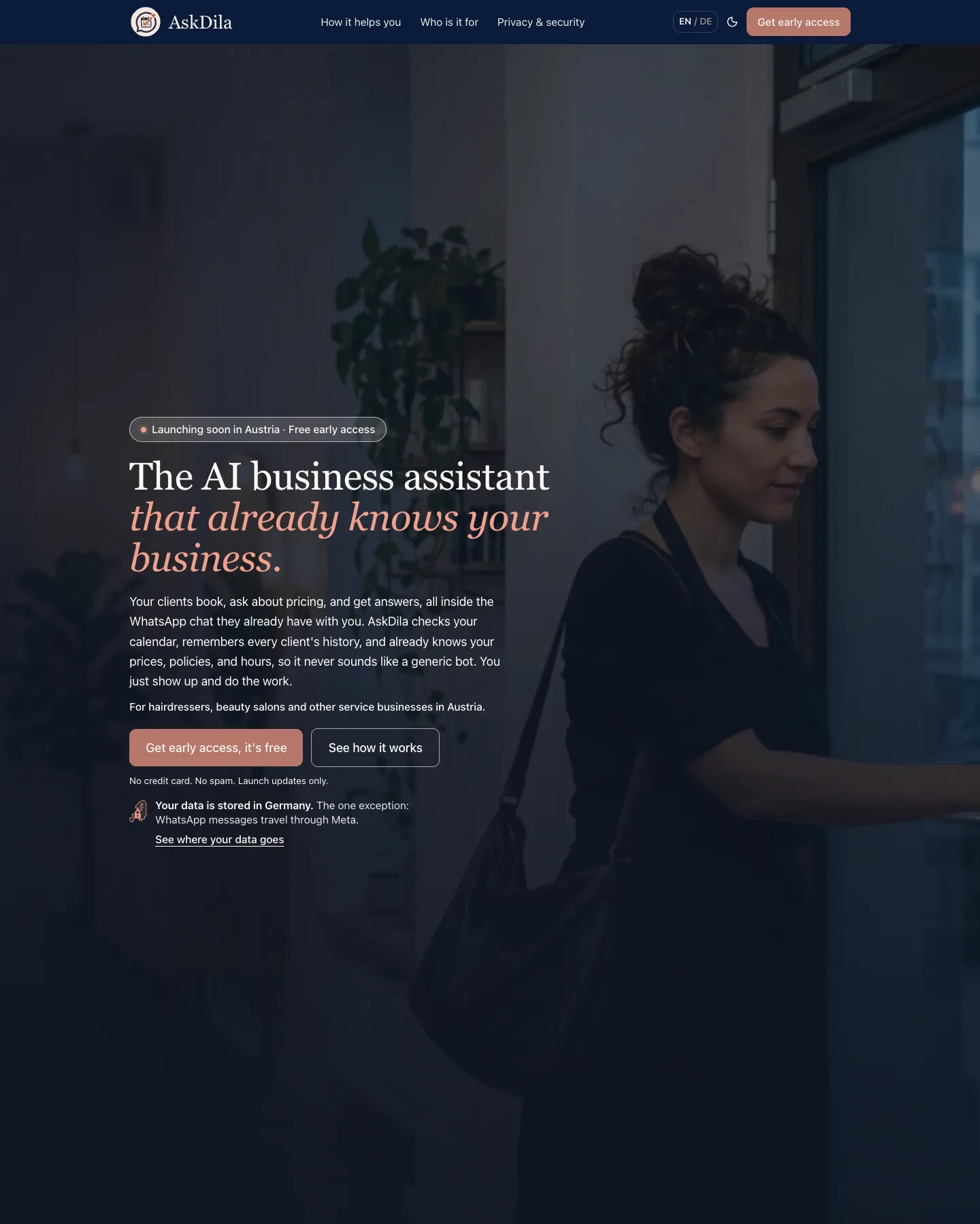 AskDila homepage: the headline "The AI business assistant that already knows your business." over a dimmed photo of a woman at a doorway, with two call-to-action buttons and a note that data is stored in Germany.